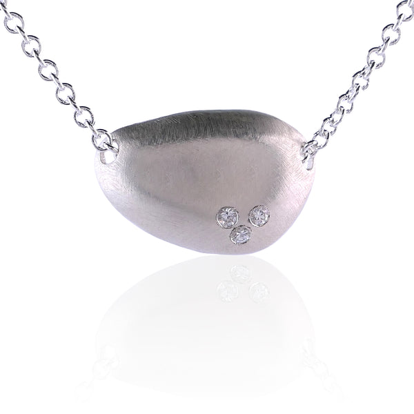 Silver necklace with a pendant featuring three small moissanites on a white background